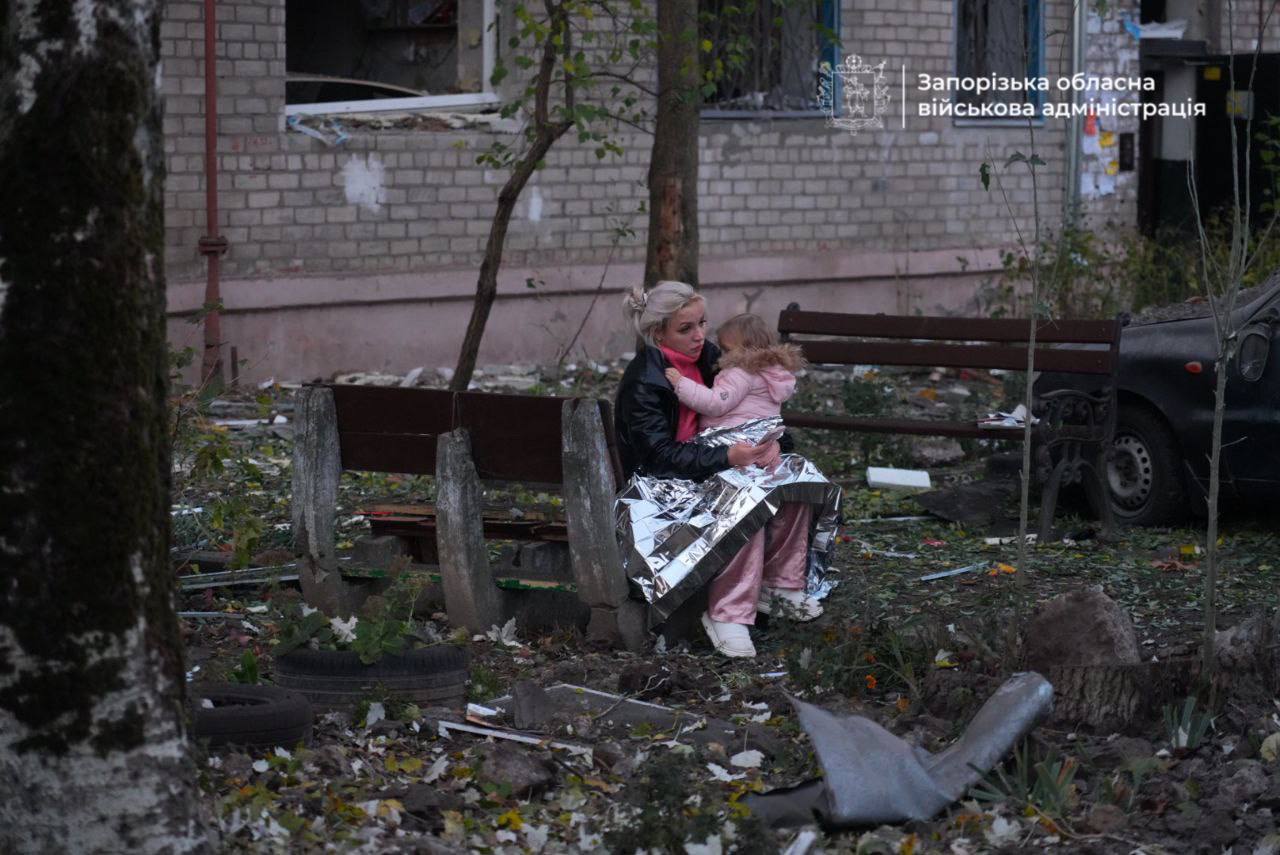 Мати та дитина біля розтрощеного російськими фашистами будинку у Запоріжжі